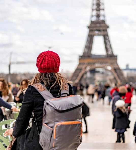 Woman is travelling in Paris in front of Eiffel Tower